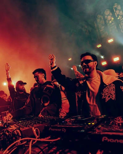 DJs performing under red and green stage lights