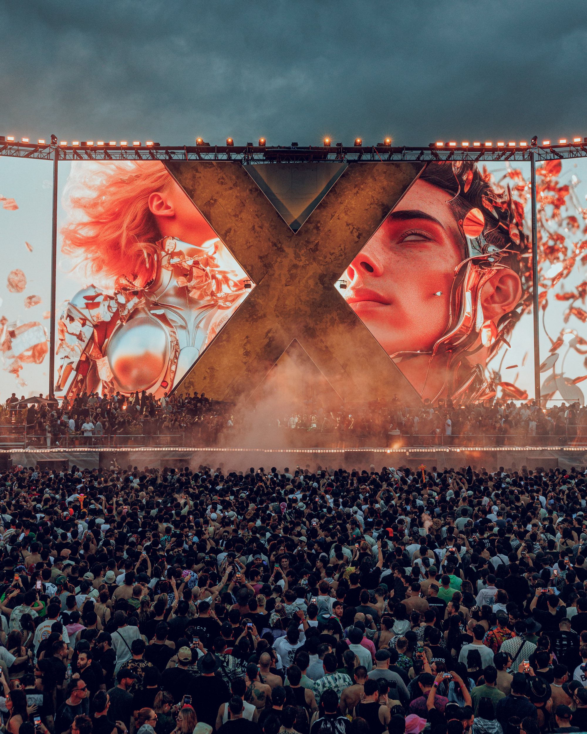 Zamna crowd facing a giant X stage with digital artwork